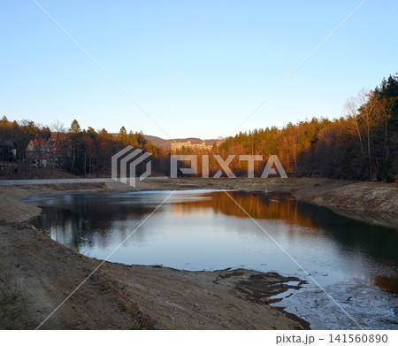 Peaceful wetland under pastel sky. Serene conservation area with soft skies and lush habitat borders Peaceful wetland under pastel sky. Serene conservation area with soft skies and lush habitat borders 141560890