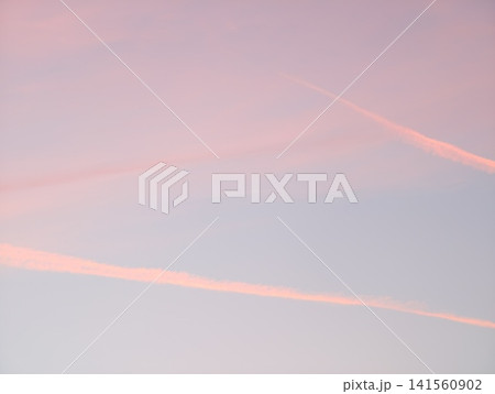 Pink sky artwork. Calm morning sky showcases intersecting vapor trails in delicate pastel tones Pink sky artwork. Calm morning sky showcases intersecting vapor trails in delicate pastel tones 141560902