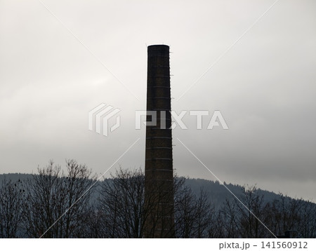 Rural landscape depiction. Tranquil scene where nature overtakes former industrial structures today Rural landscape depiction. Tranquil scene where nature overtakes former industrial structures today 141560912
