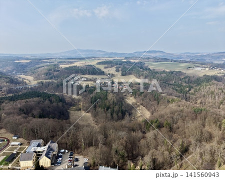 Forest hills meet city outskirts. Aerial perspective captures suburbs beside wooded mountain slope Forest hills meet city outskirts. Aerial perspective captures suburbs beside wooded mountain slope 141560943