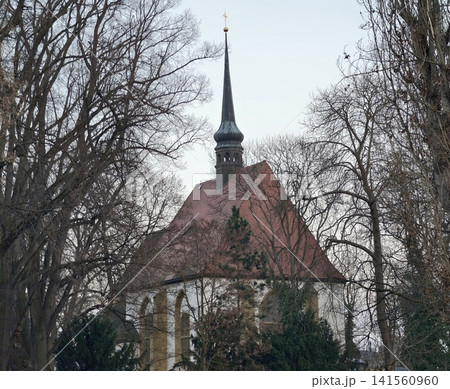 Ancient church with tall steeple. Heritage church features towering spire and scenic park setting Ancient church with tall steeple. Heritage church features towering spire and scenic park setting 141560960