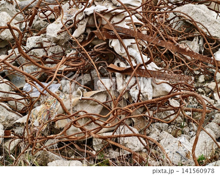 Chaotic scene displaying weathered iron bars intertwined with shattered concrete in salvage yard setting Chaotic scene displaying weathered iron bars intertwined with shattered concrete in salvage yard setting 141560978