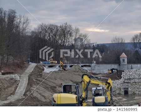 Multiple tracked excavators cooperate diligently to reinforce riverbanks and prevent flooding Multiple tracked excavators cooperate diligently to reinforce riverbanks and prevent flooding 141560995