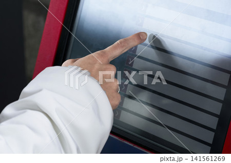 Person buying a ticket at a station ticket machine, illustrating modern self service technology for quick public transport access. 141561269