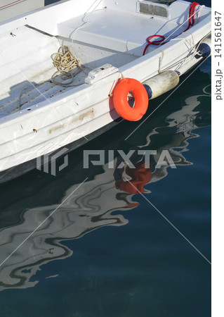 Small white boat with orange ring buoy Small white boat with orange ring buoy 141561647