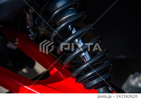 Close-up of automotive shock absorber with red suspension components 141562620