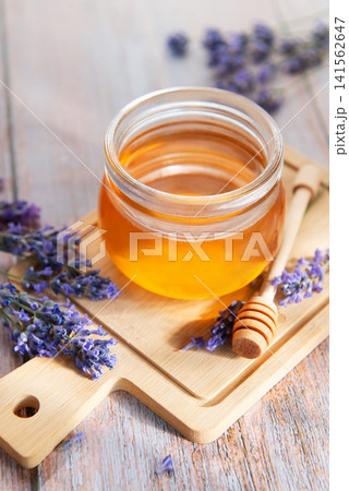 Honey jar with lavender flowers on wooden board Honey jar with lavender flowers on wooden board 141562647