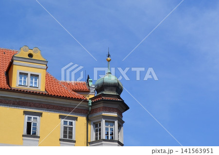 Colorful prague rooftop with red tile and copper turret under clear blue sky for travel background and architectural banner. Prague. Copy space Colorful prague rooftop with red tile and copper turret under clear blue sky for travel background and architectural banner. Prague. Copy space 141563951