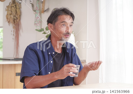 内服薬を飲もうとするシニア男性 141563966
