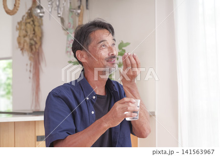 内服薬を飲もうとするシニア男性 内服薬を飲もうとするシニア男性 141563967