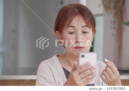 スマホと錠剤を手に健康管理をする女性 141563991