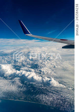 夏空に広がる雄大な積乱雲と機窓の風景 141564238