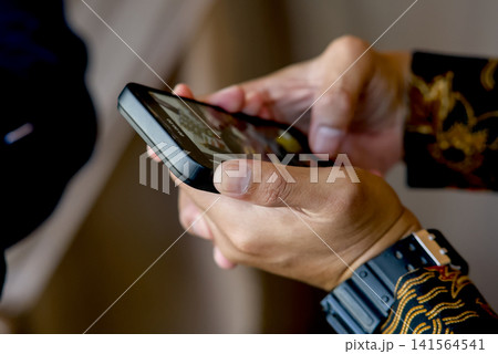 the man in the black suit using a smartphone the man in the black suit using a smartphone 141564541