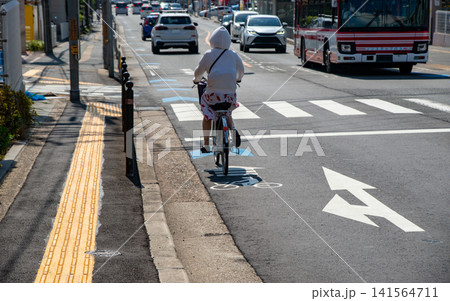 自転車レーンを走る自転車と街中の交通風景 自転車レーンを走る自転車と街中の交通風景 141564711