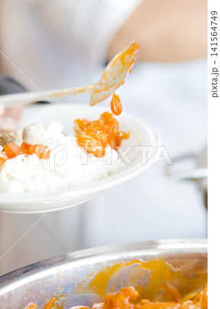 Close-up view of a festive dining moment showing a hand reaching for delicious food served on the table. Close-up view of a festive dining moment showing a hand reaching for delicious food served on the table. 141564749