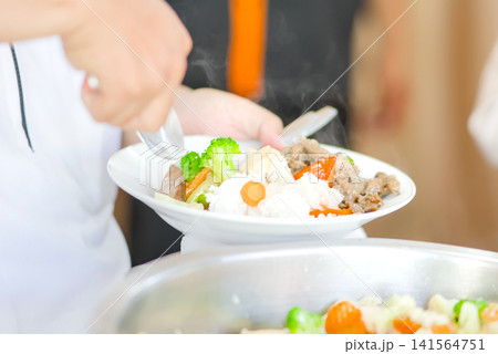 Close-up view of a festive dining moment showing a hand reaching for delicious food served on the table. Close-up view of a festive dining moment showing a hand reaching for delicious food served on the table. 141564751