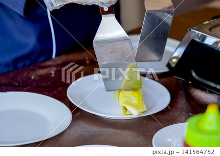 Close-up view of a festive dining moment showing a hand reaching for delicious food served on the table Close-up view of a festive dining moment showing a hand reaching for delicious food served on the table 141564782