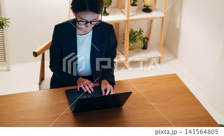 暗い部屋でパソコンを見るミドル女性。デスクワーク、テレワーク、フリーランス、仕事、SE、エンジニア 暗い部屋でパソコンを見るミドル女性。デスクワーク、テレワーク、フリーランス、仕事、SE、エンジニア 141564805