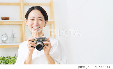 カメラを持つ女性。写真、撮影、笑顔、カメラ女子、趣味、デジカメ、副業、スキル、動画、ミドル、スタジオ 141564833