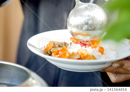 Close-up view of a festive dining moment showing a hand reaching for delicious food served on the table 141564859