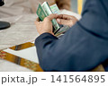A close-up capture of a traditional wedding ceremony moment, highlighting the groom seated beside the officiant  141564895