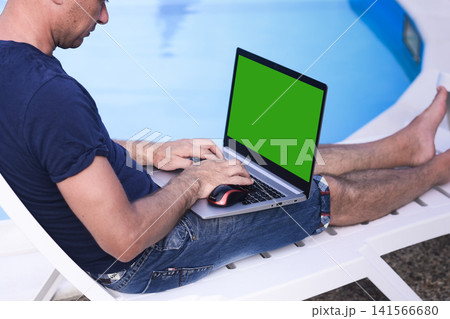 Laptop with male working outdoors on beach chair. laptop. Laptop with male working outdoors on beach chair. laptop. 141566680