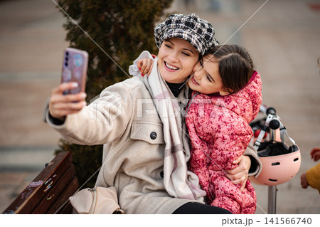 Mother and daughter taking selfie outdoors in winter Mother and daughter taking selfie outdoors in winter 141566740