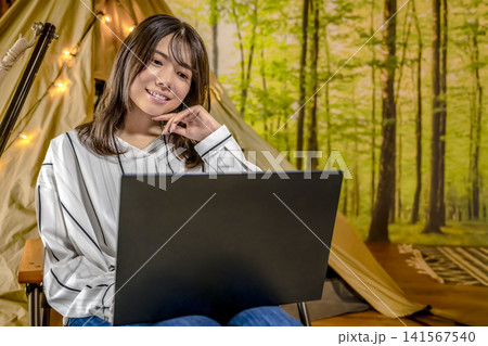 グランピングでワーケーションをする若い女性 グランピングでワーケーションをする若い女性 141567540