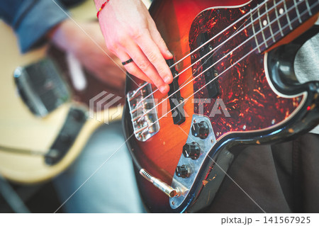 Close-up of Hand Playing Electric Bass Guitar Strings Close-up of Hand Playing Electric Bass Guitar Strings 141567925