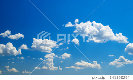 multiple white cumulus clouds across spacious blue sky multiple white cumulus clouds across spacious blue sky 141568294