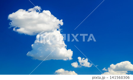large cumulus cloud on the left against a clear blue summer sky on a bright day 141568306
