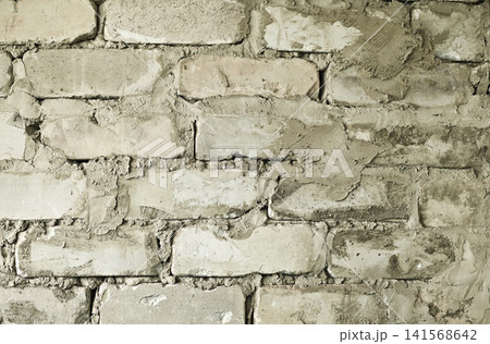 Old brick wall texture shows rough cement joints between stones. Old brick wall texture shows rough cement joints between stones. 141568642