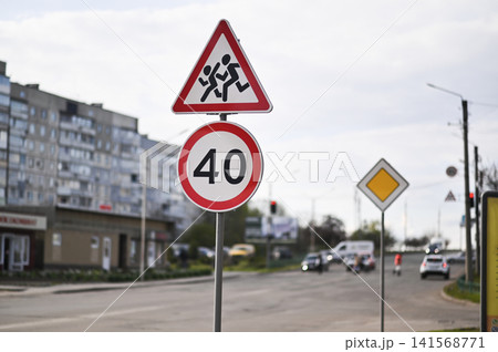 Triangular road sign warns drivers about children crossing near school. 141568771