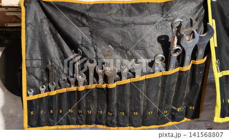 Wrench set with metal spanners organized in fabric holder. Wrench set with metal spanners organized in fabric holder. 141568807