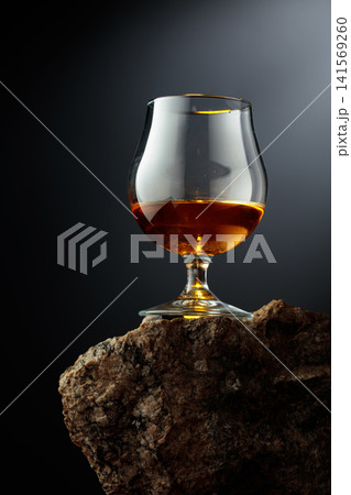 Glass of brandy on a rough granite. Glass of brandy on a rough granite. 141569260