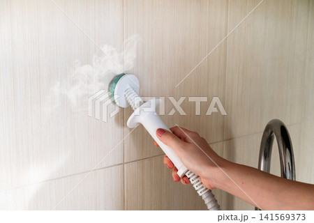 Cleaning the white sink and faucet in the bathroom with a steam generator. Releases steam. Combats mold and calcium. Cleaning the white sink and faucet in the bathroom with a steam generator. Releases steam. Combats mold and calcium. 141569373