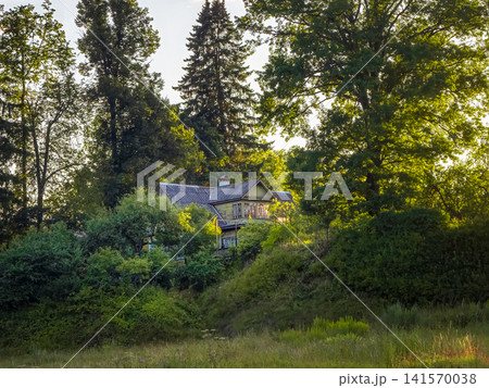 a landscape with an apartment building located on a hill and surrounded by dense greenery a landscape with an apartment building located on a hill and surrounded by dense greenery 141570038