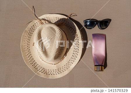 Flat Lay of Summer Essentials Straw Hat Sunglasses and Cosmetic Tube Flat Lay of Summer Essentials Straw Hat Sunglasses and Cosmetic Tube 141570329