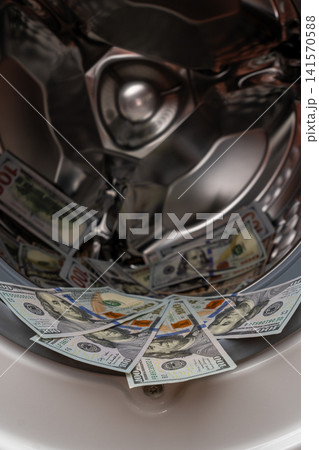 One hundred dollar bills inside open washing machine drum closeup One hundred dollar bills inside open washing machine drum closeup 141570588