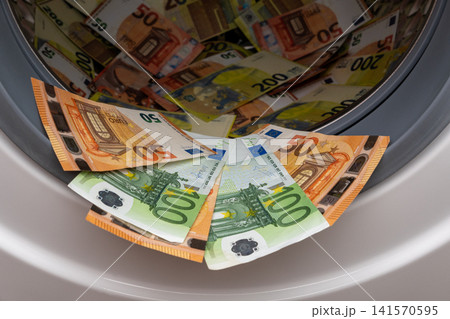Euro banknotes inside open washing machine drum closeup Euro banknotes inside open washing machine drum closeup 141570595