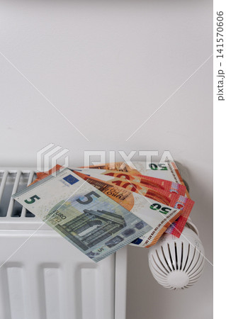 Euro banknotes on central heating radiator with thermostat valve Euro banknotes on central heating radiator with thermostat valve 141570606