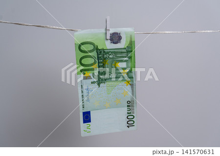 One Hundred Euro Banknote Hanging on Clothesline for Money Laundering Concept 141570631