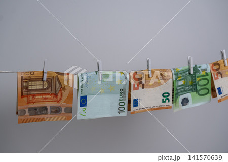 Five Euro Banknotes Hanging on Clothesline for Money Laundering Concept Five Euro Banknotes Hanging on Clothesline for Money Laundering Concept 141570639