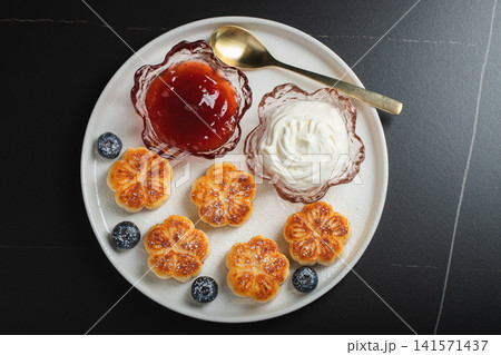 Cottage cheese pancakes, syrniki, curd fritters decorated with strawberry and raspberry served on a white plate. Homemade breakfast concept 141571437
