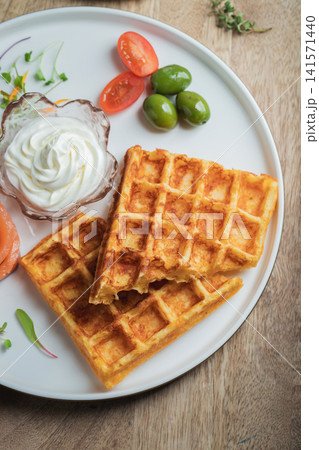 Crunchy waffle fries with sour cream dip served in a basket Crunchy waffle fries with sour cream dip served in a basket 141571440