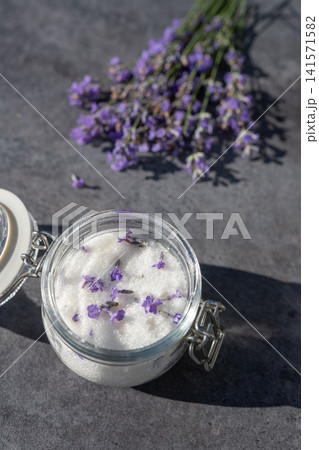 Homemade lavender sugar in glass jar with fresh flowers on dark background. 141571582