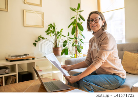 Cheerful middle aged female specialist looking at camera Cheerful middle aged female specialist looking at camera 141571722
