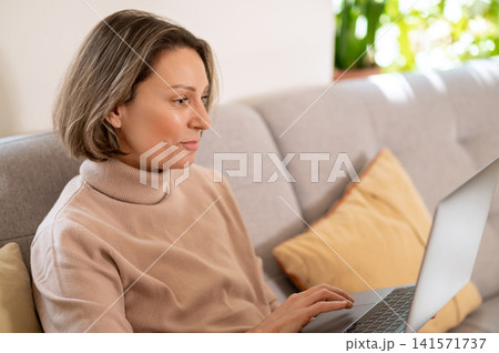 Middle aged woman using laptop computer 141571737