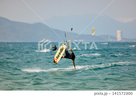 Kitesurfer Performing One Handed Water Drag Turn Kitesurfer Performing One Handed Water Drag Turn 141572800