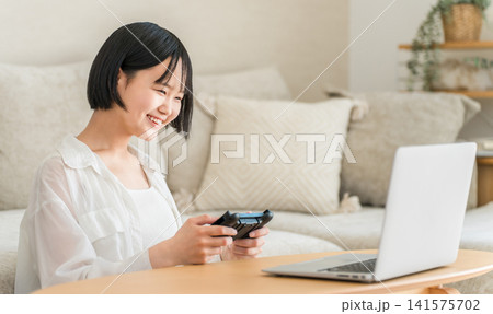 リビングでオンラインゲーム,テレビゲームをする中学生,高校生の女の子 141575702